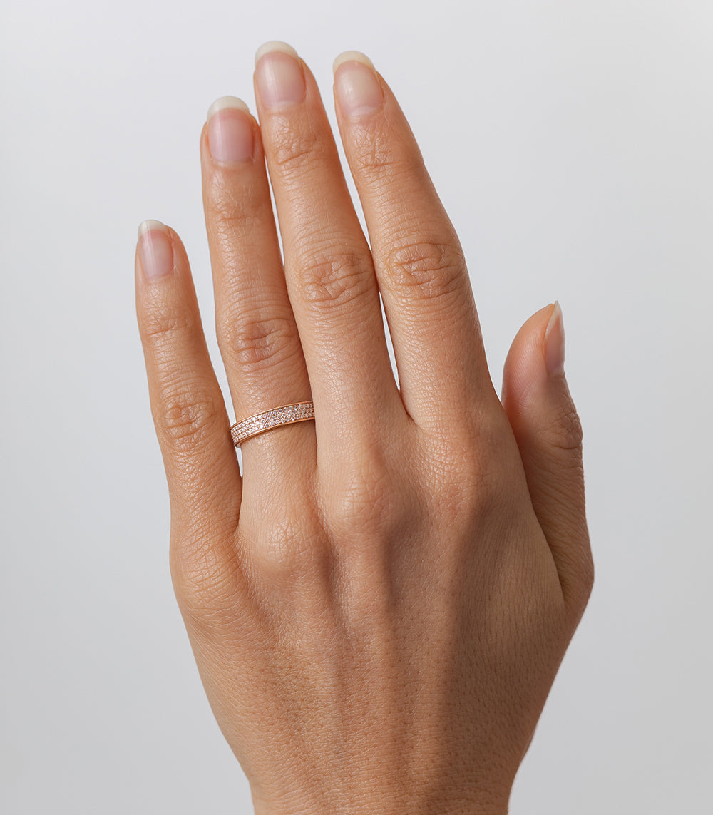 Glitterati by A-R21-3M shiny rose gold pave band ring on a hand with clear sparkle lighting