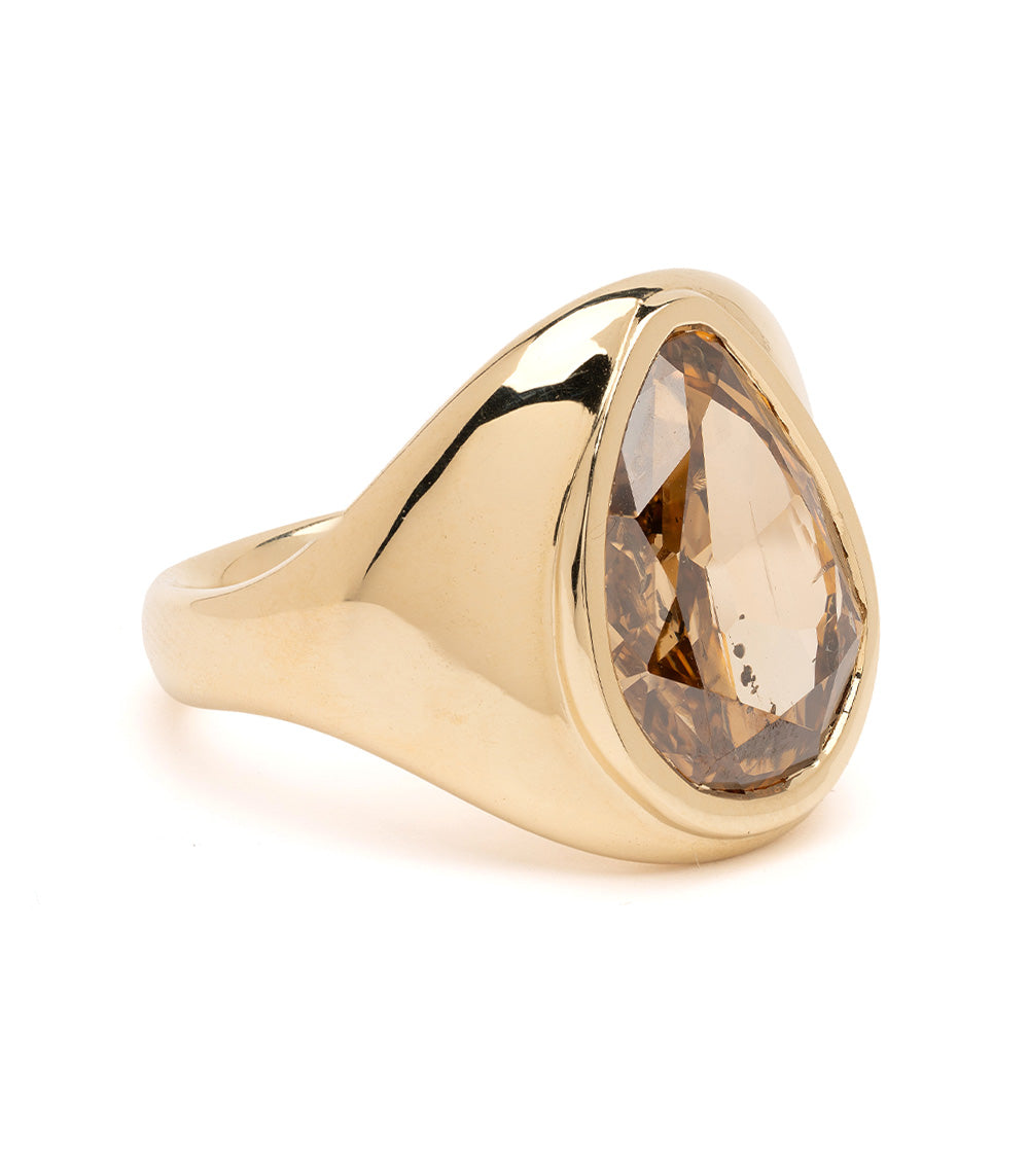 Gold ring with a large brown gemstone on a white background