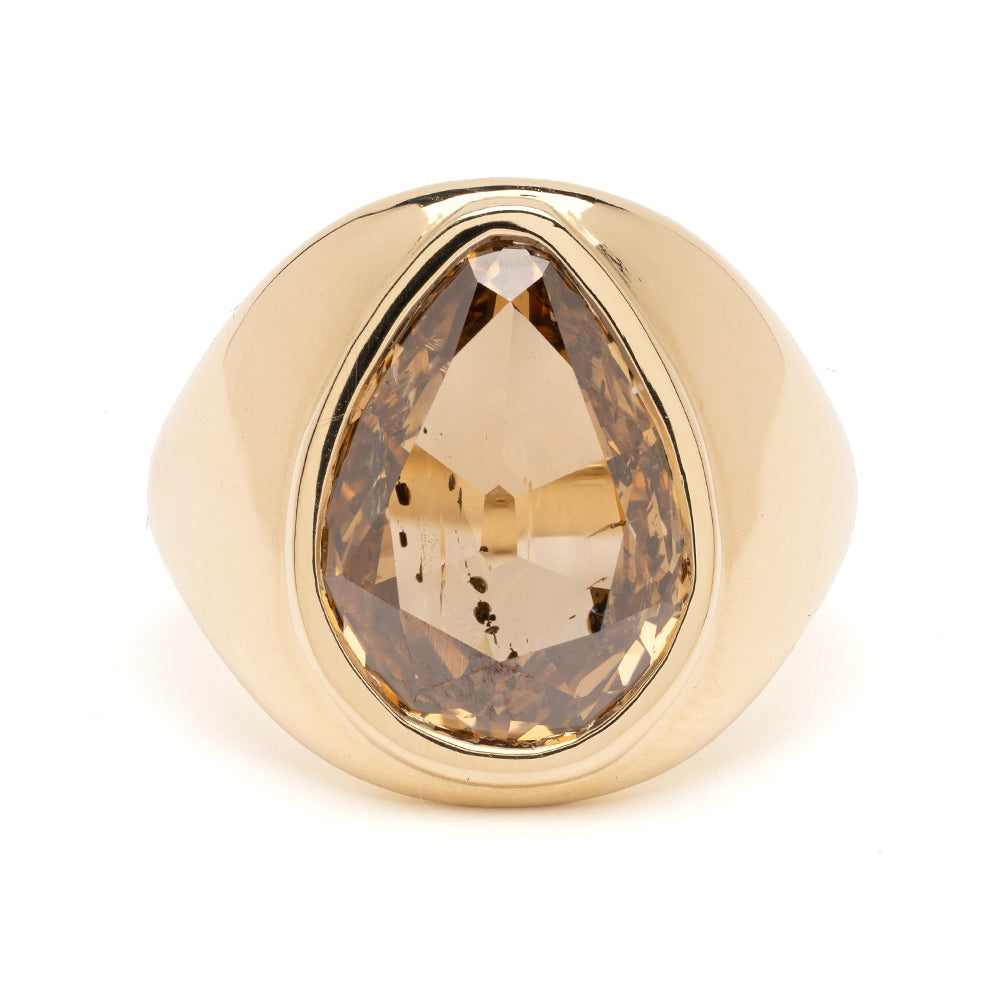 Gold ring with a large brown gemstone on a white background