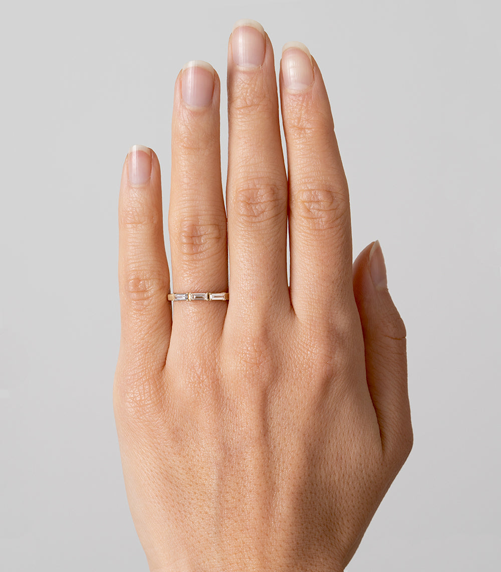 Stardust SK-R77 bands gold ring with small shiny stones, understated sparkle on an open hand