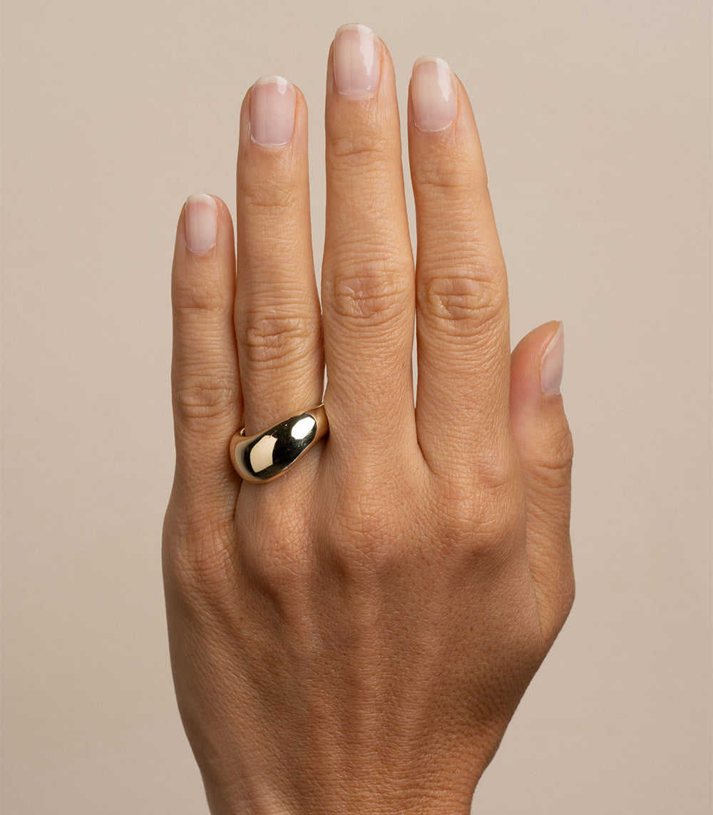 Mega Melt shiny yellow gold ring by EGB-R17 with understated smooth bezel shine on finger