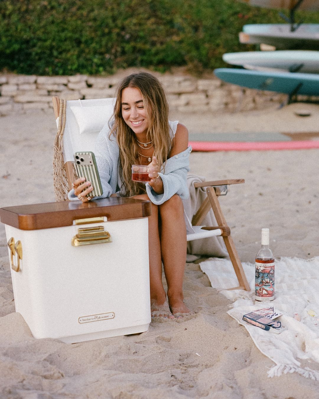 film-shot-of-Julia-havens-holding-phone-on-beach-with-wine-in-hand-mobile