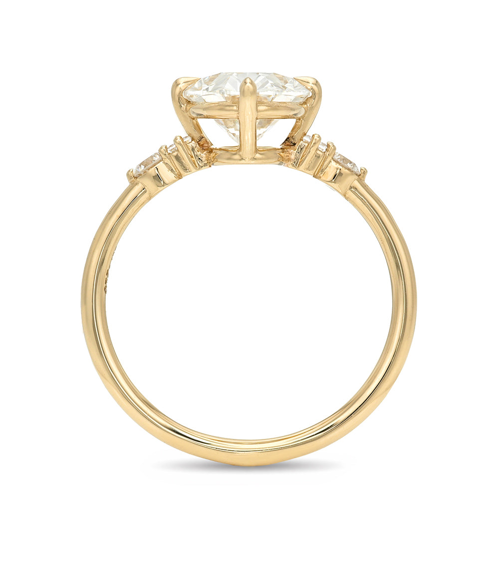 Gold ring with a central diamond and smaller stones on a white background