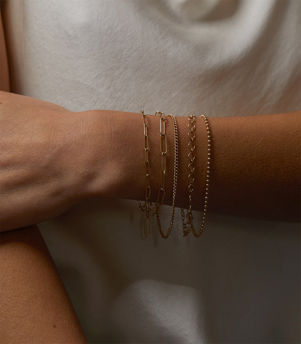 The Crush Bracelet CB-C4 gold chain bracelets stacked on wrist with short links and clasp