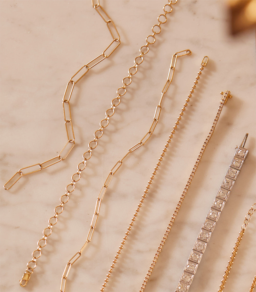 The Trendy Bracelet by CB-C3 in gold chain links, featuring mixed bracelet styles on display.