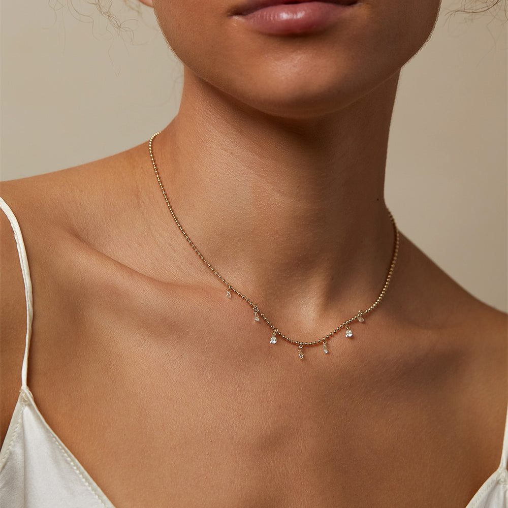 Effervescence Necklace SK-N6 gold pendant necklace with small dangling charms and sparkle on collarbone