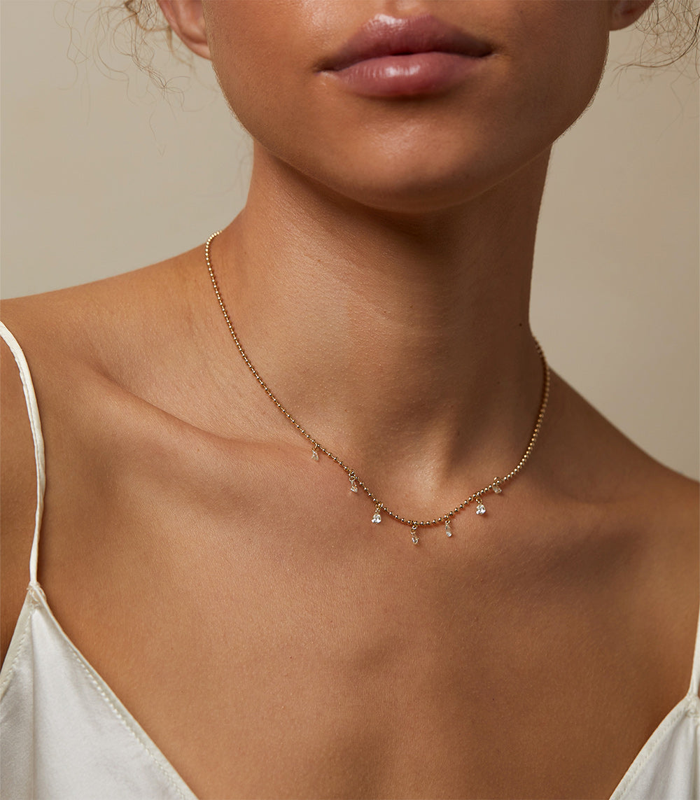 Effervescence Necklace SK-N6 gold pendant necklace with small dangling charms and sparkle on collarbone
