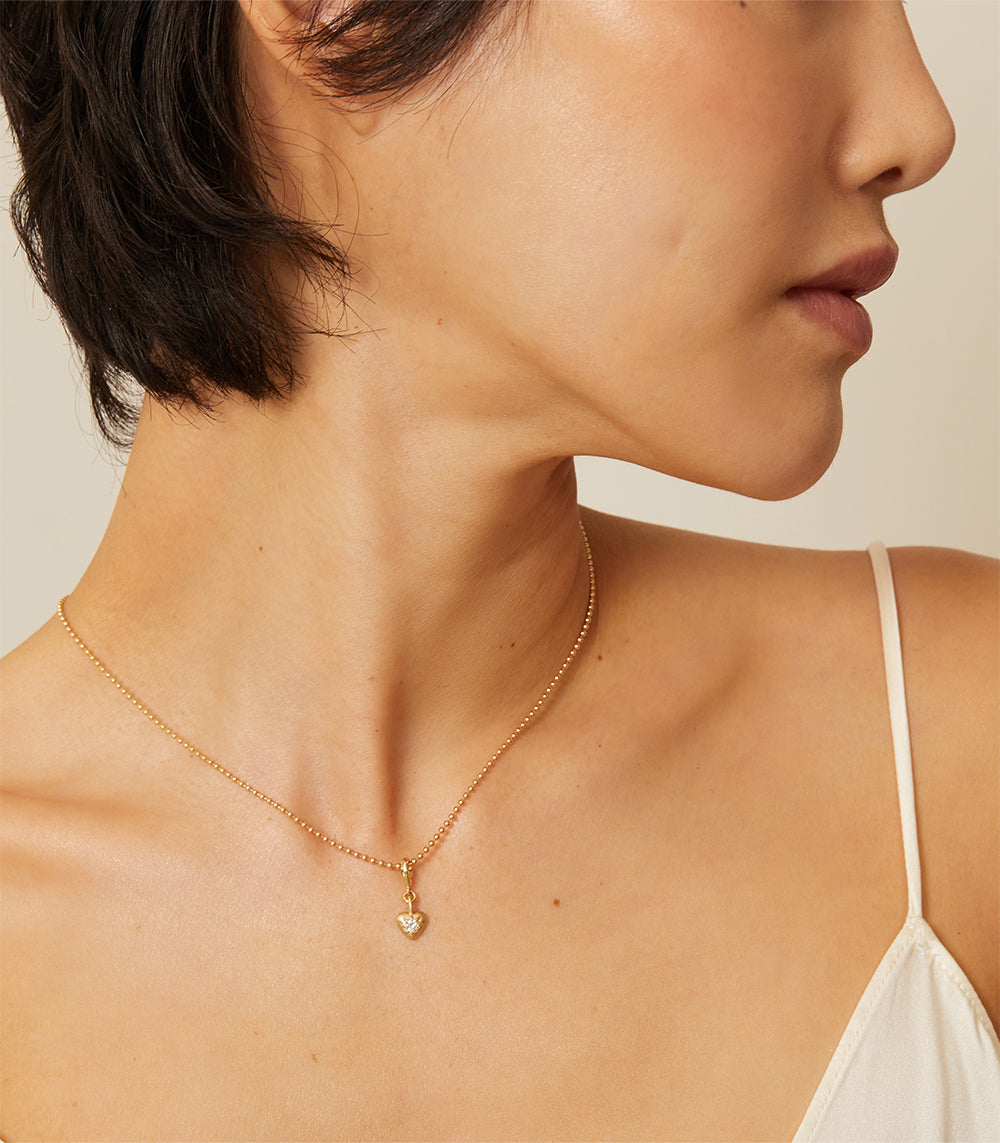 Cora Mini Charm KM-P10 shiny gold necklace with small heart charm on a delicate chain
