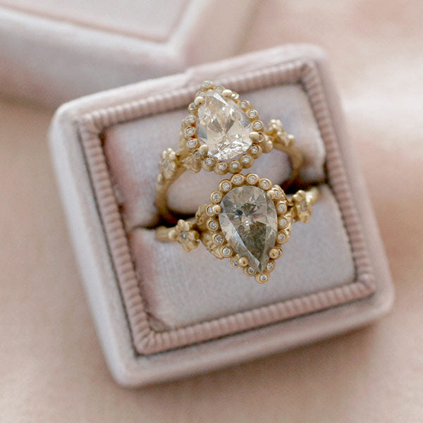 Unique engagement ring with an asymmetrical 2 stone diamond setting in gold, resting in a ring box