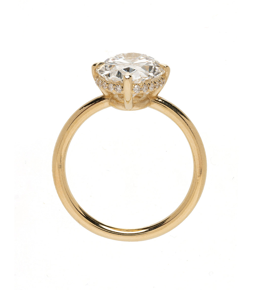 Annika Sofia Kaman engagement ring in yellow gold with round diamond center and pavé shoulders.