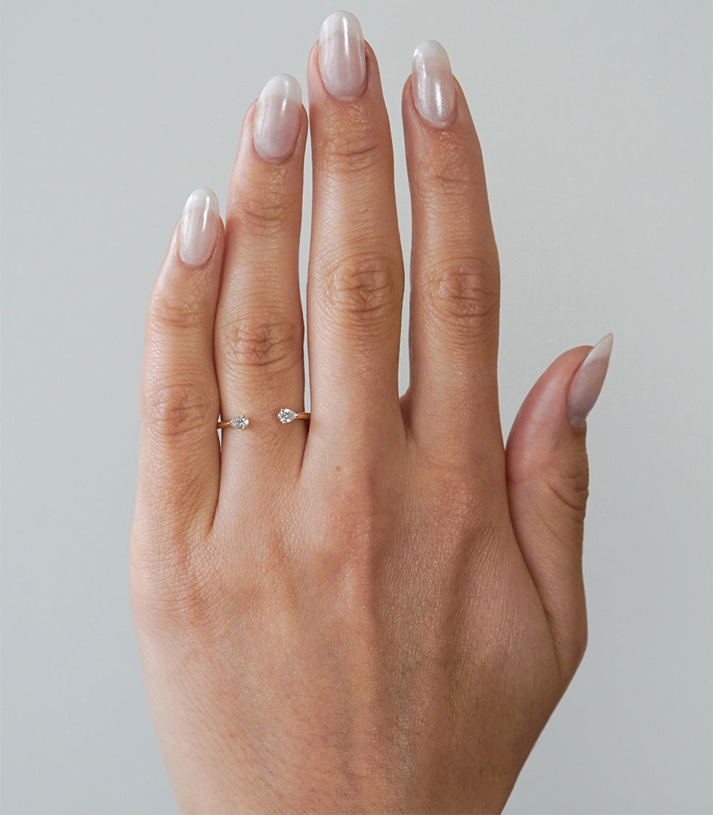 Lunetta by A-R38-PC 2 stone engagement ring on a finger with two small shiny diamonds
