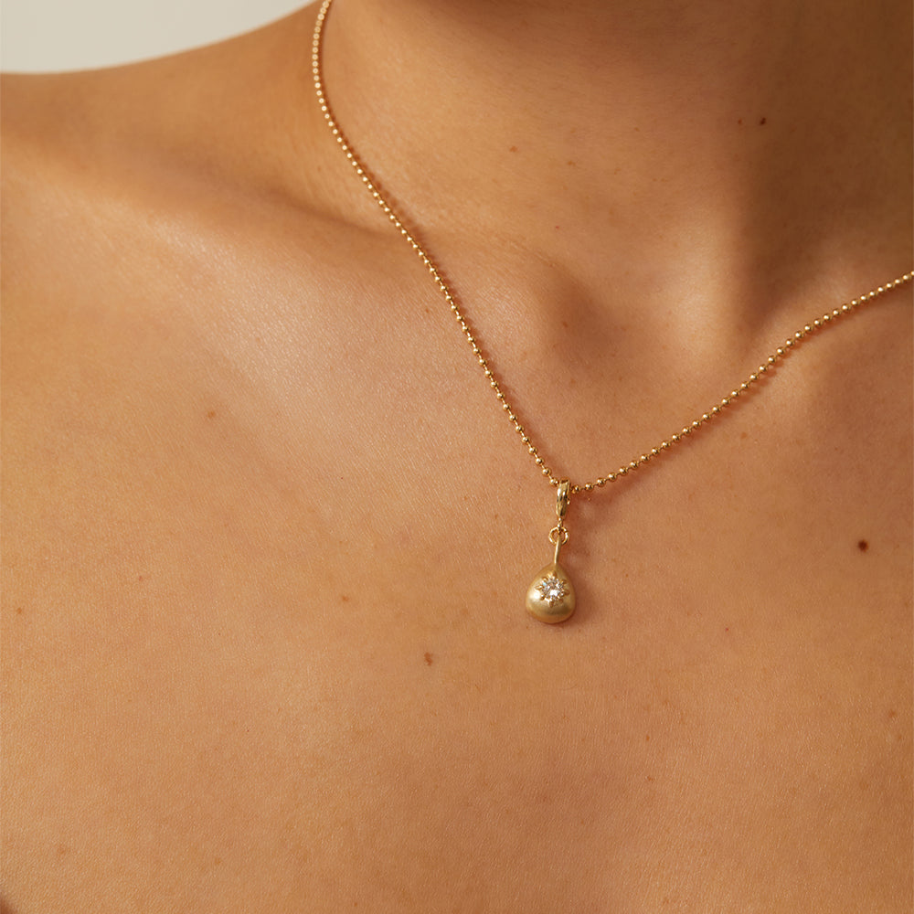 Cora Mini Charm by KM-P9 mini gold charm necklace with shiny clasp and teardrop pendant on skin