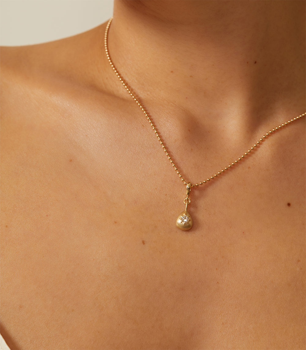Cora Mini Charm by KM-P9 mini gold charm necklace with shiny clasp and teardrop pendant on skin