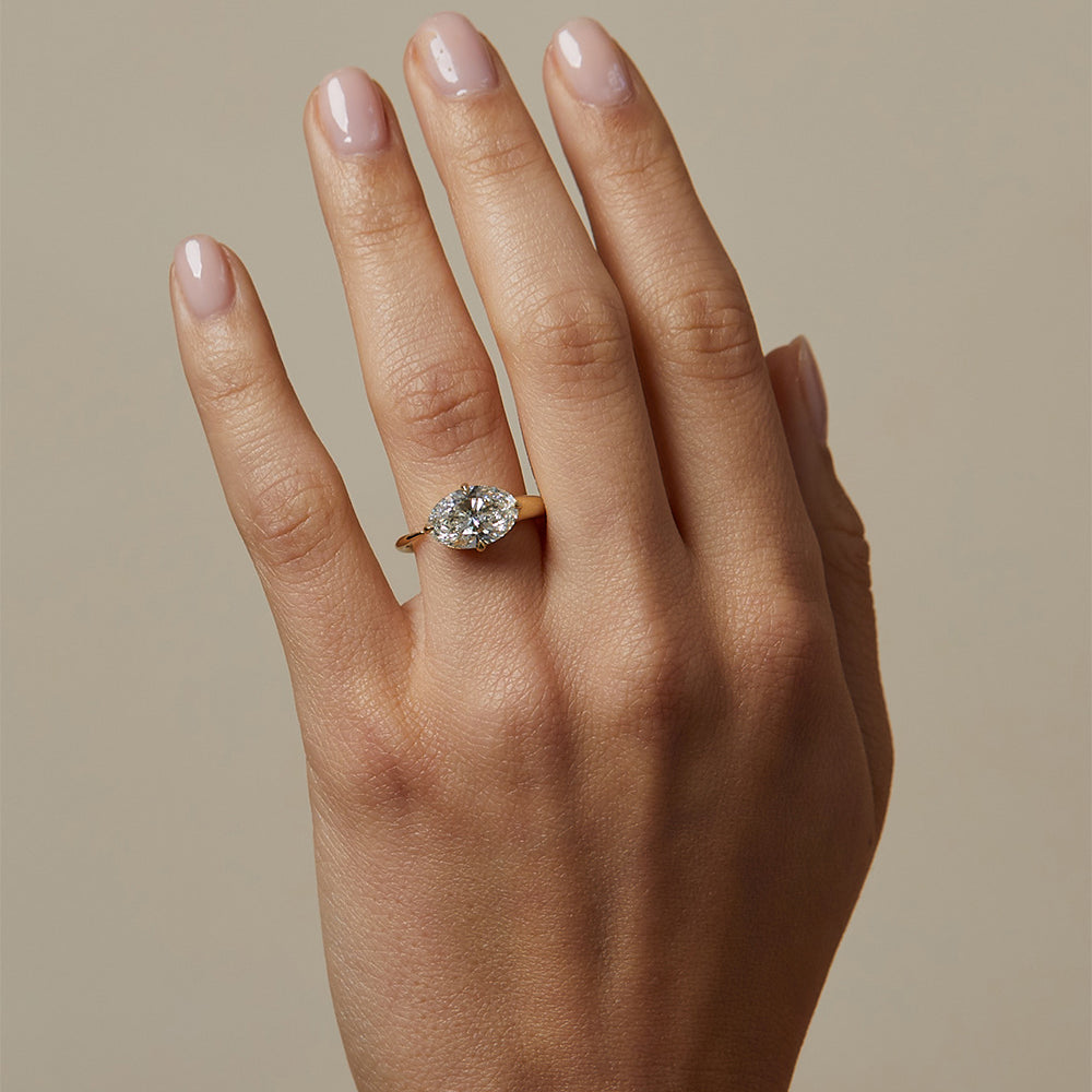 Sloane SK-R86-EW-LGD-OB-2.67 gold engagement ring with round-cut diamond solitaire on hand, soft light