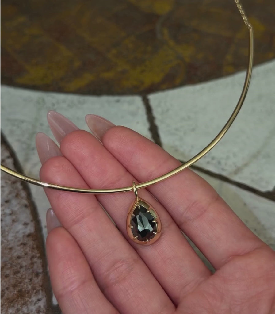 14K yellow gold half collar chain necklace with a black rosecut diamond shown pendant, shown with hands.
