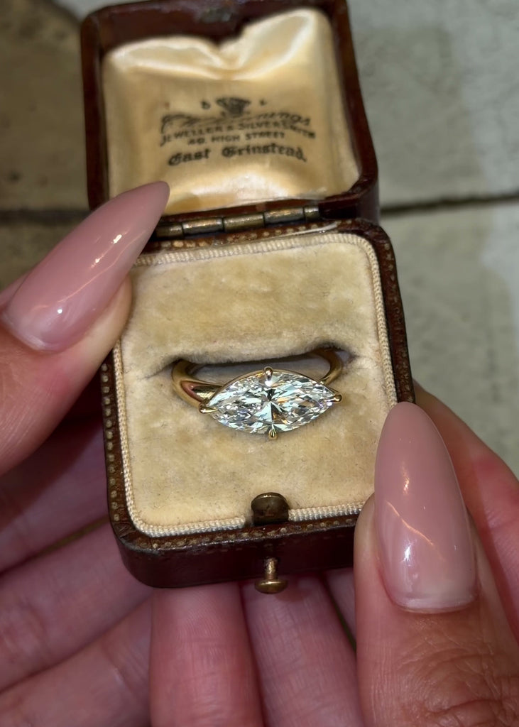 East West lab grown marquise shape diamond engagement ring on a tapered 14K yellow gold rounded band.
