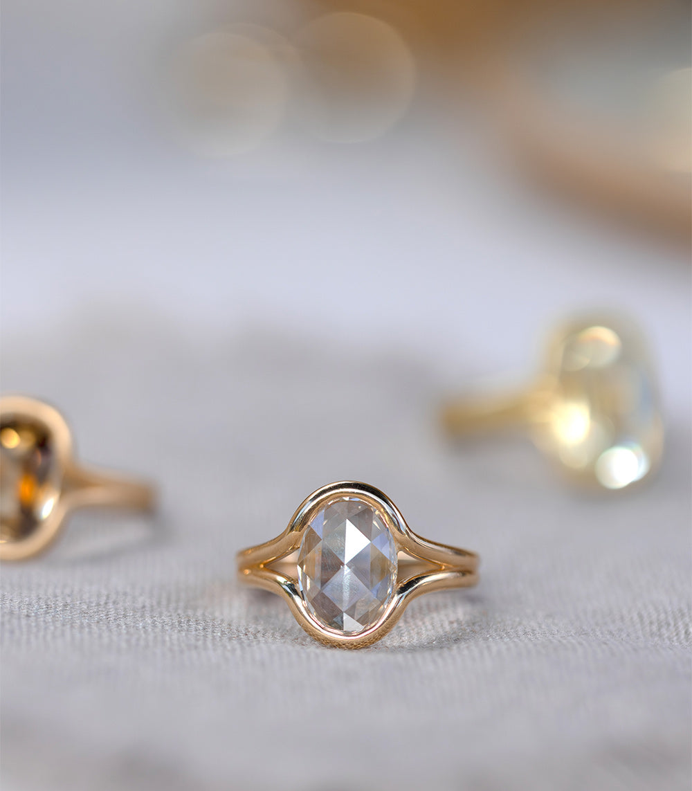 Onda by SK-R114-LGD-ORC-1.97 gold unique engagement ring with oval clear center stone on light fabric
