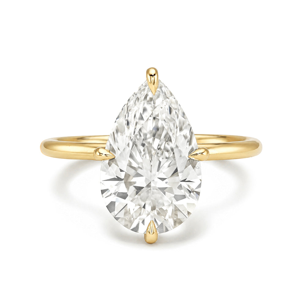 Annika Sofia Kaman unique engagement ring in gold with understated prong-set marquise diamond center
