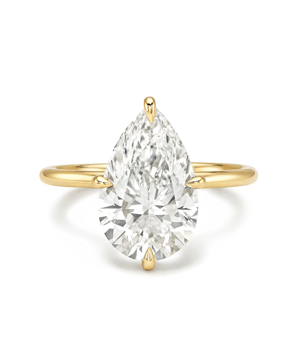 Annika Sofia Kaman unique engagement ring in gold with understated prong-set marquise diamond center