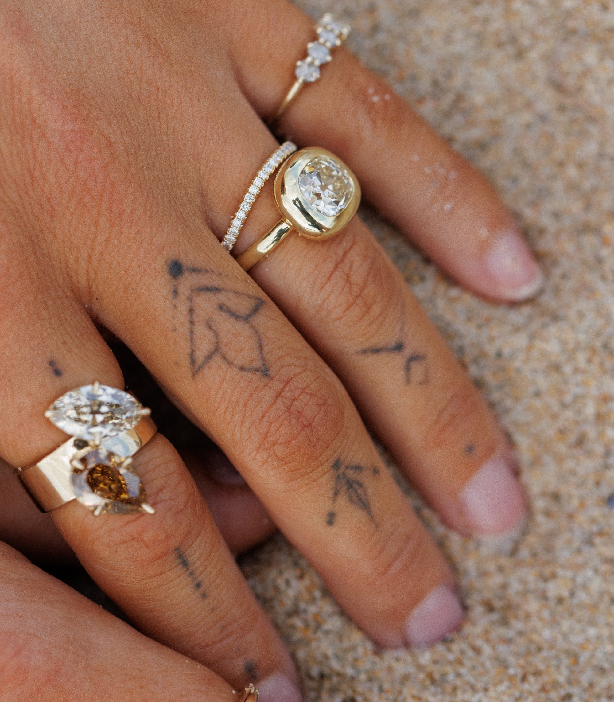 Tattooed Hand In Sand With Natural Champagne Diamond Toi Et Mois Style Rings