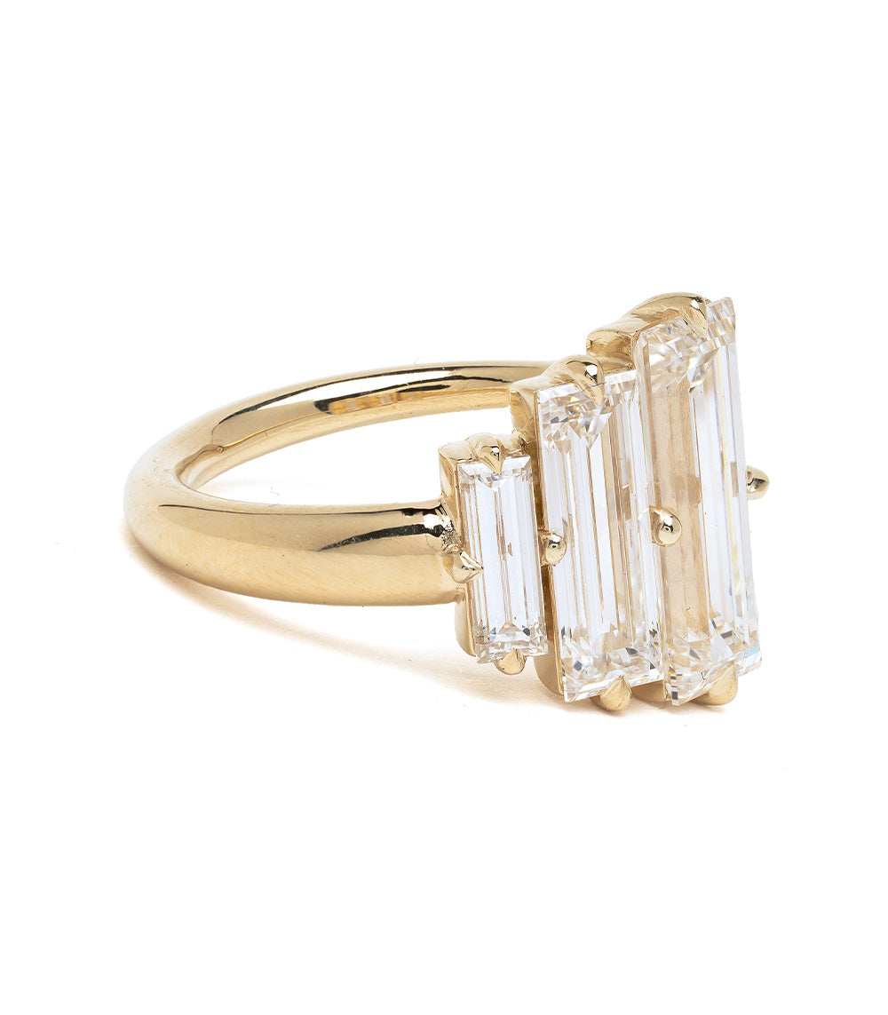 Gold ring with three rectangular diamonds on a white background