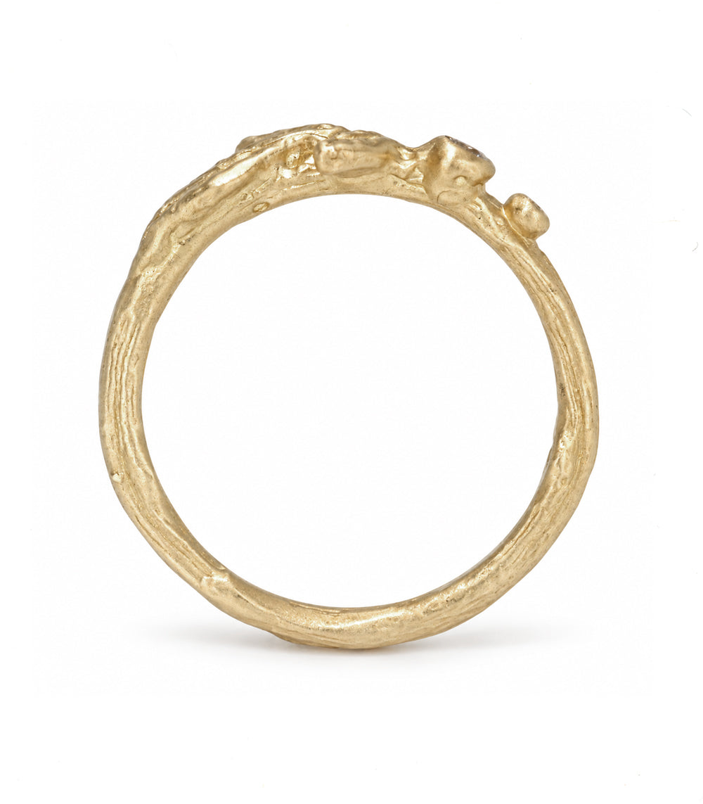 A textured organic-shaped gold ring with a rough, bark-like surface and small protruding details, shown on a clean white background.