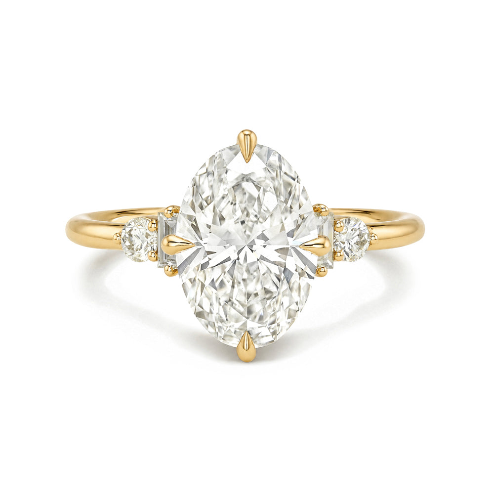 Gold ring with a large diamond and smaller diamonds on the band against a white background
