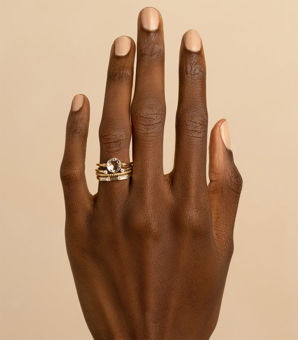 Tiny Coil Band A-R45 ring in 14K yellow gold with shiny coil texture on a hand close-up