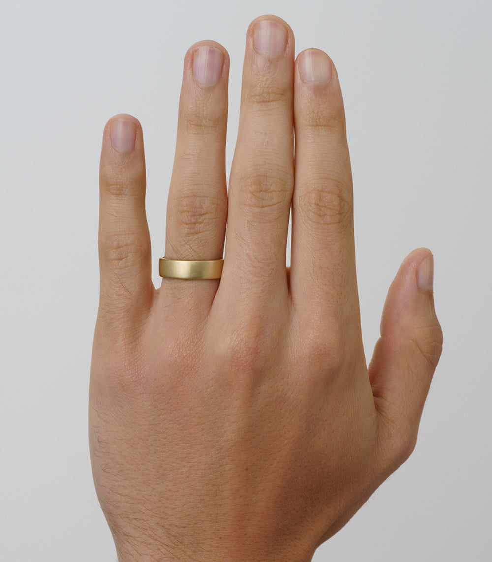 Smooth Classic Band 6MM SB-R12 smooth ring on finger in shiny gold, 6MM minimalist band finish.