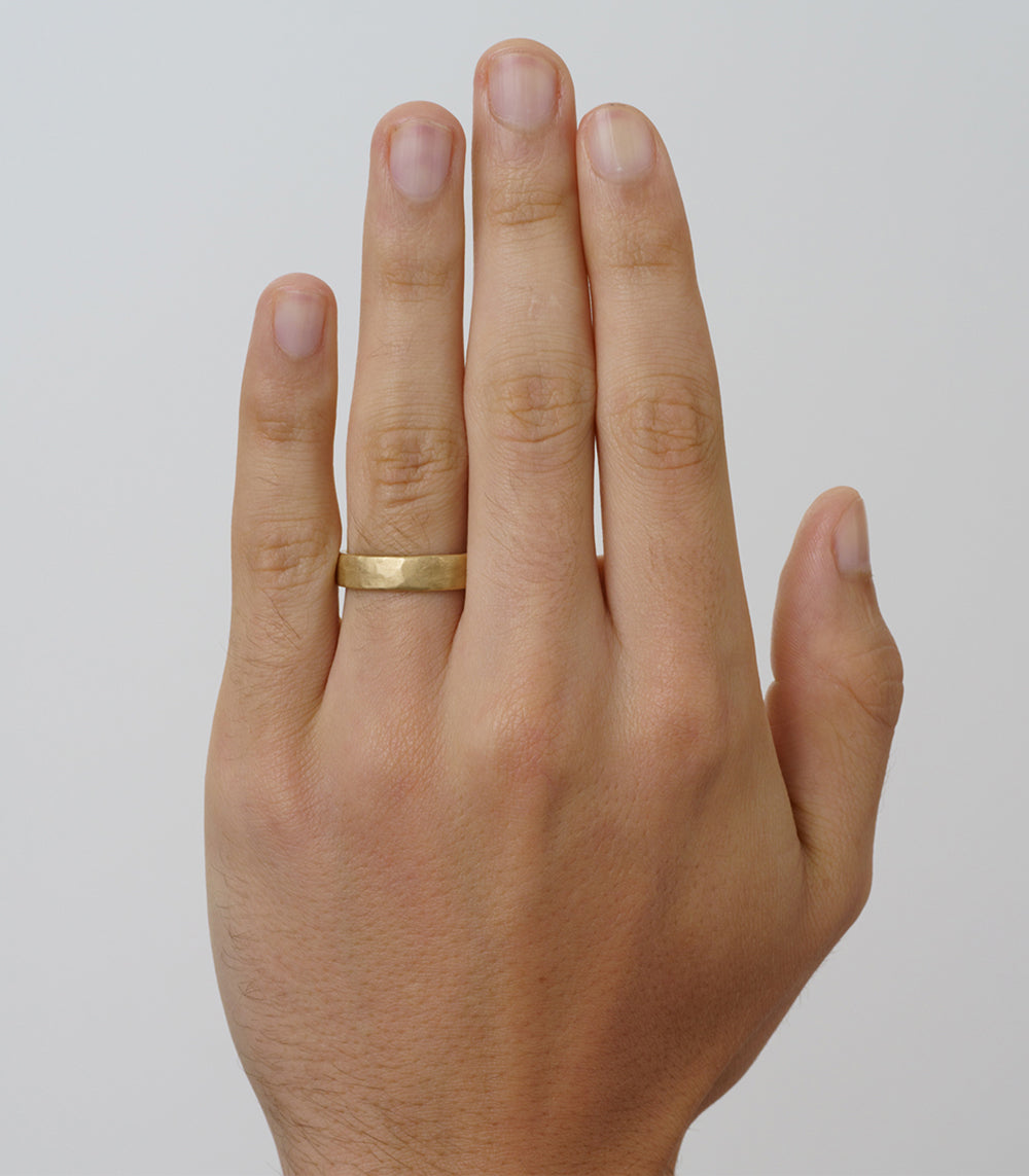Raw Texture Wedding Band M-R1-5 14K yellow gold shiny band on finger, raw hammered texture