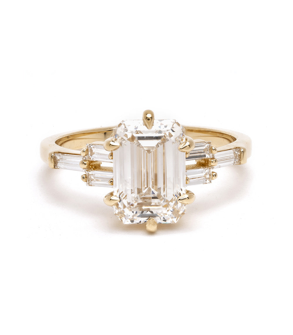 Unique engagement ring with gold band, emerald-cut center stone and baguette side stones, understated sparkle