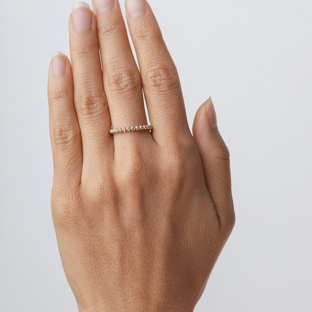 Bubble Band R-R14 ring band in 14k yellow gold with shiny bubble stones, on hand