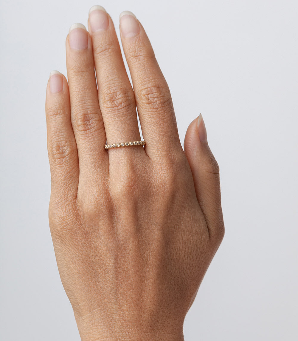 Bubble Band R-R14 ring band in 14k yellow gold with shiny bubble stones, on hand