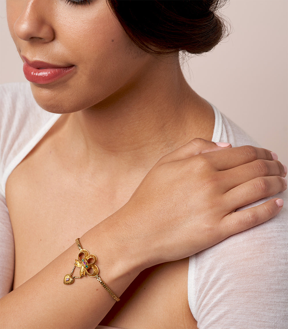 Spellbound Bow Bracelet by VC-B11, gold-tone bracelet with bow charm and small purple stone accents.