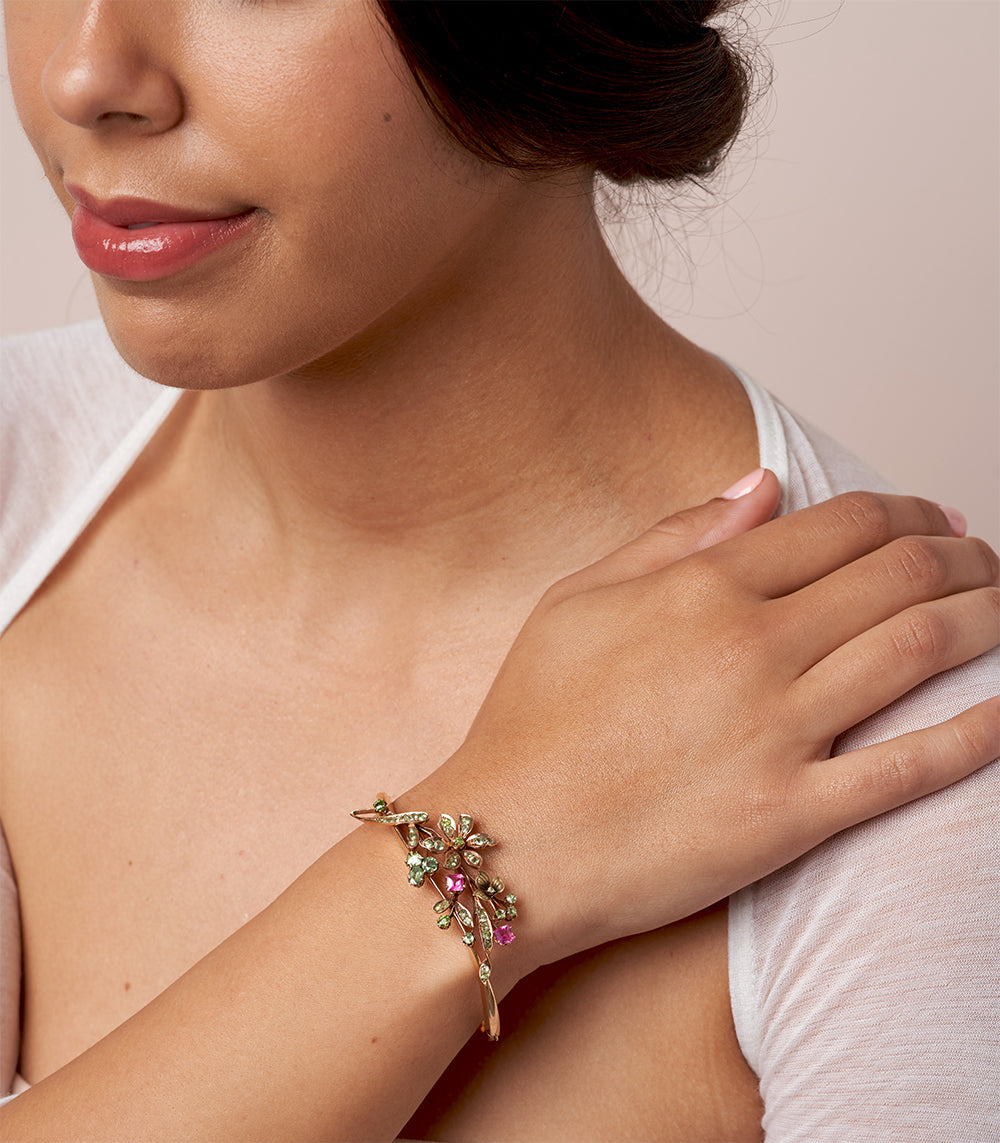 Whimsical Flower Bangle VC-B10 multicolored floral gemstone bracelet on model wrist, gold tone