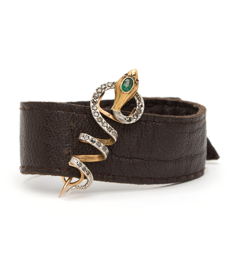 Eternally Yours Pin by VC-P8 gold and silver pin with green stone and crystal accents on brown leather.
