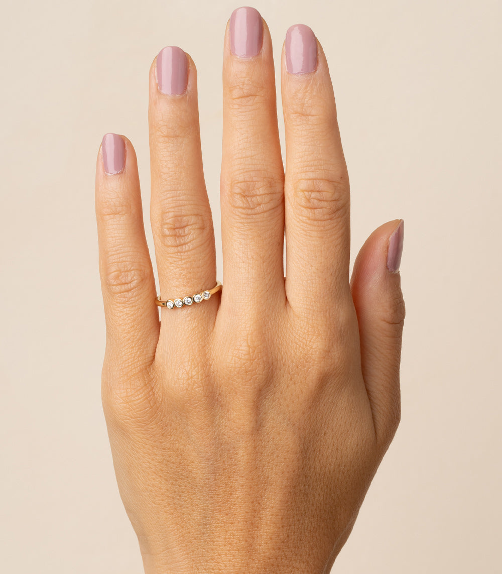 Diamond Bezels EB-R17-D5 diamond band in 14K yellow gold with shiny bezel-set stones on finger