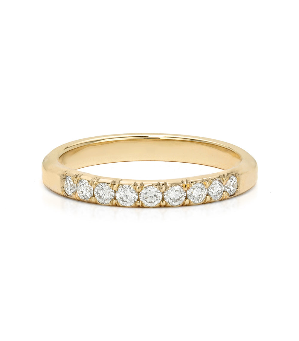 A yellow gold eternity ring featuring a row of round-cut clear diamonds set in a prong setting, shown on a clean white background.