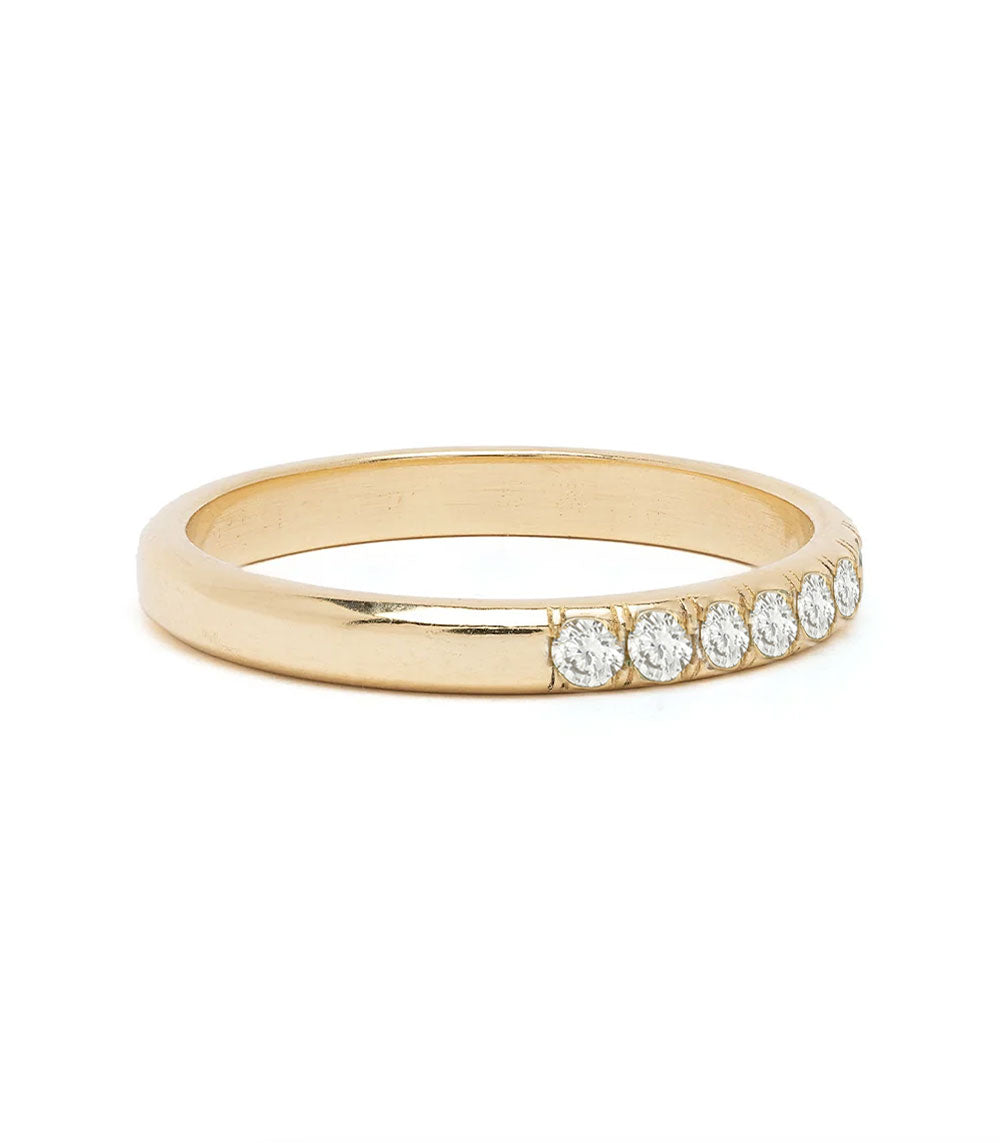 A yellow gold eternity-style ring featuring five round-cut clear gemstones set along the front edge, photographed on a clean white background.