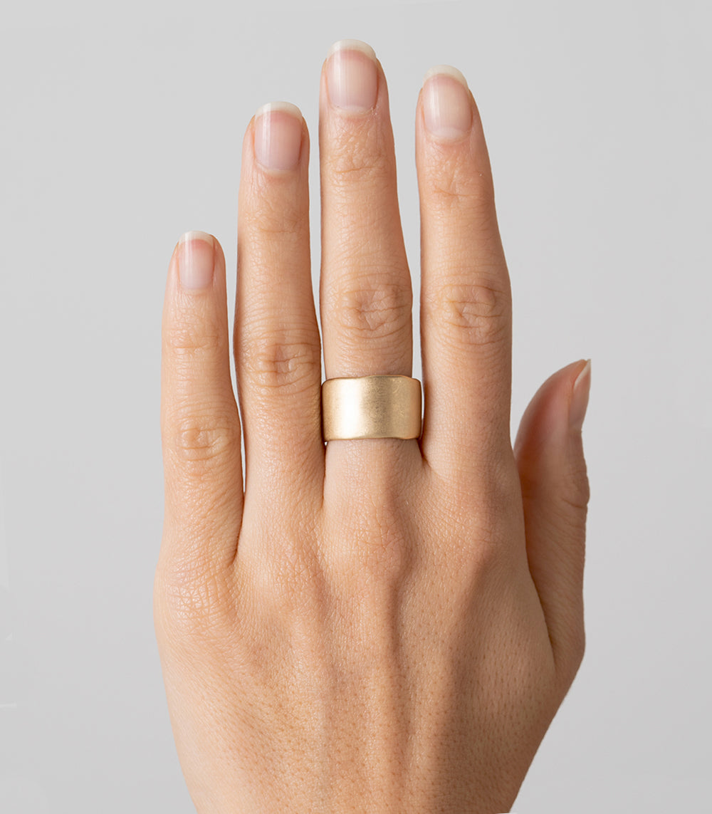 Torn Paper Band P-R5 band in 14K yellow gold with shiny torn-paper texture on a finger