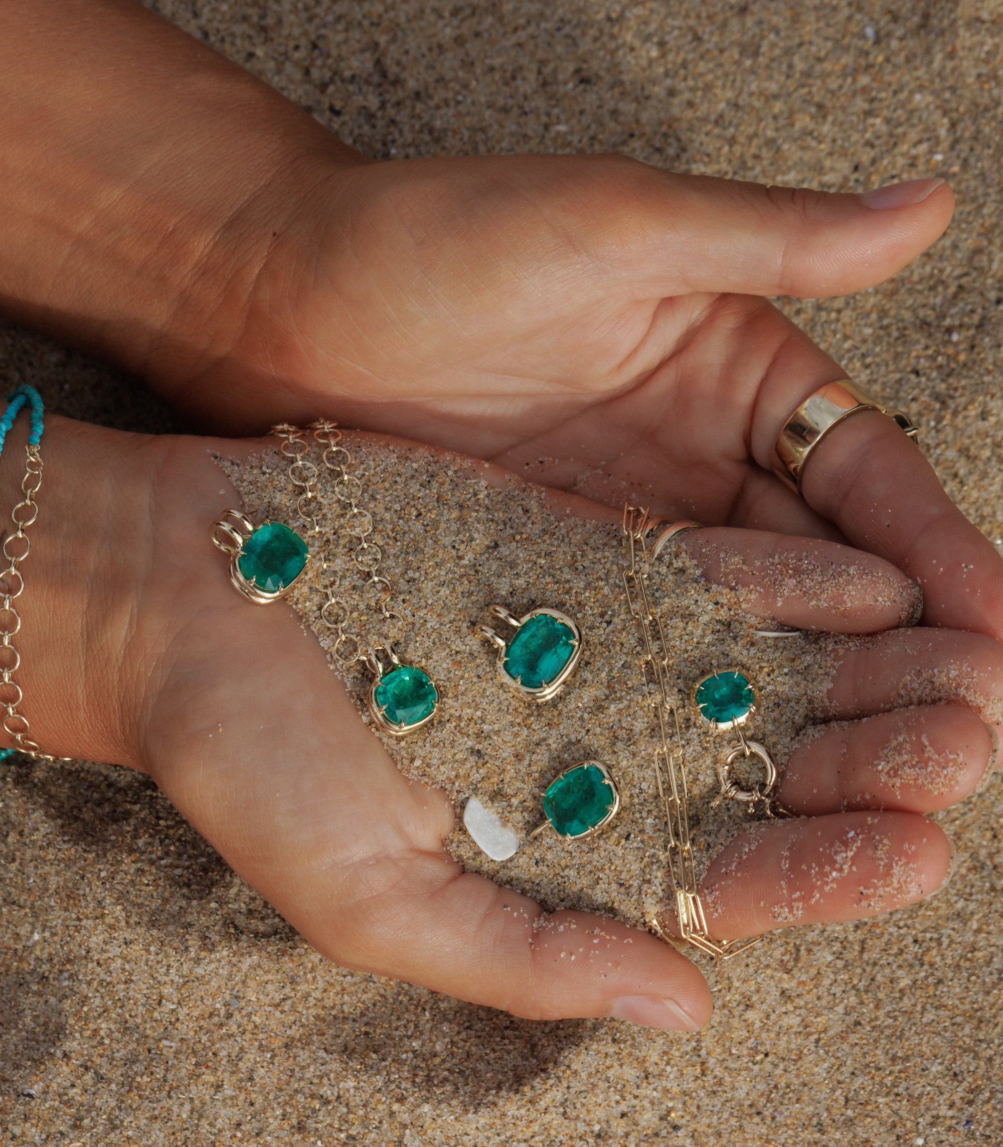 Woman Holding Hands With Sand Showing Emerald Pendants In Palms Of Hand Editorial Fine Jewelry Style