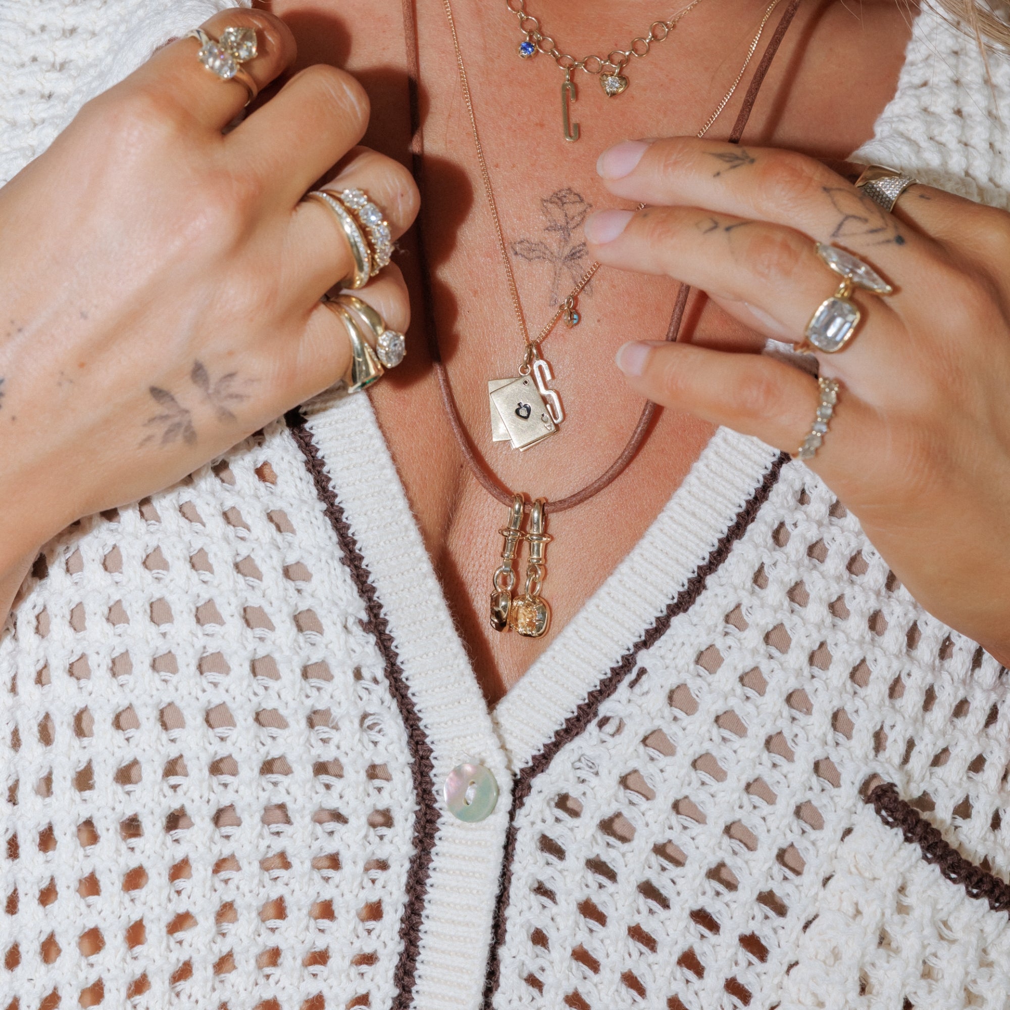 Woman Wearing Layers Of Necklaces With Diamond Pendants And Stacks Of Rings