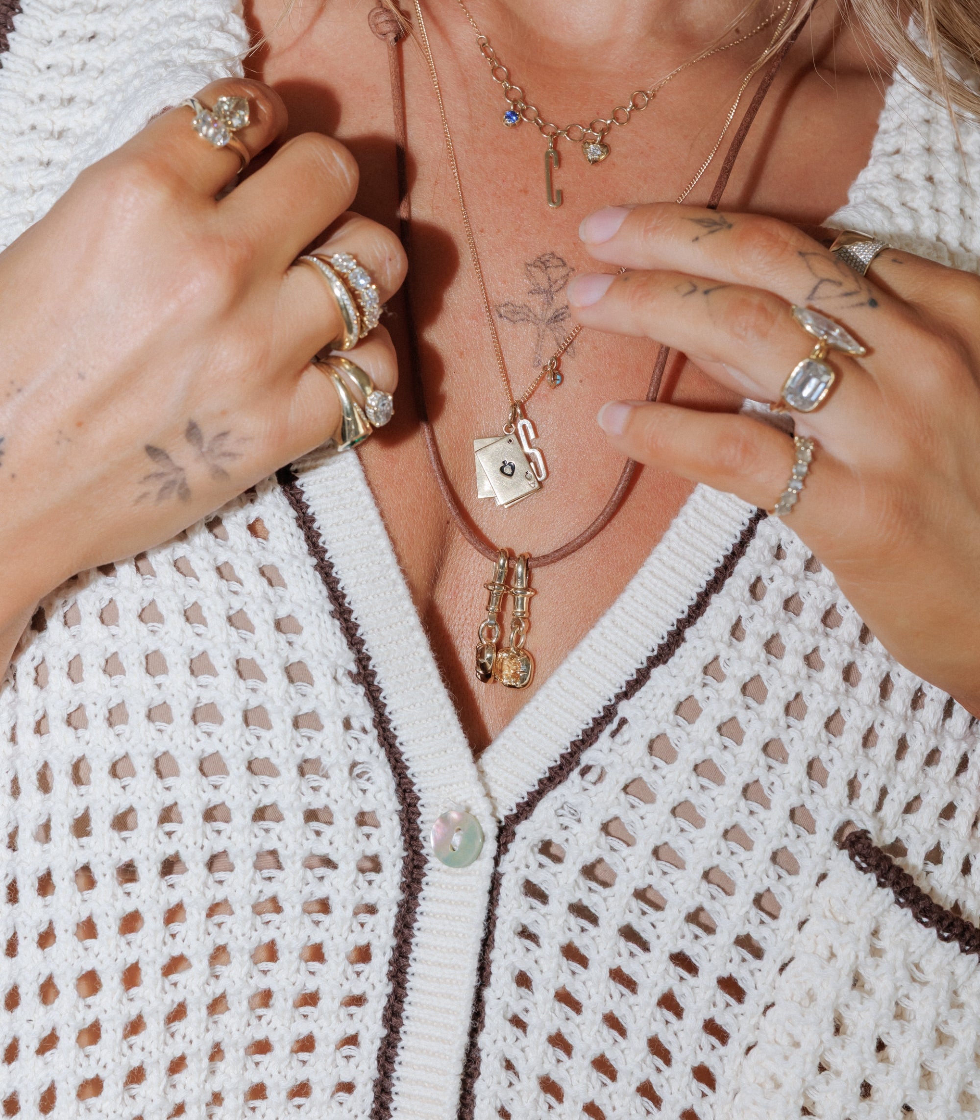 Woman Wearing Layers Of Necklaces With Diamond Pendants And Stacks Of Rings
