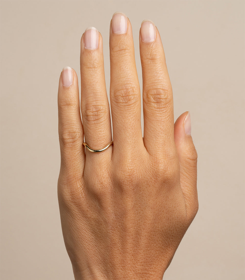 The Bold Beau Band by A-R43: shiny 14K yellow gold ring band with a slim curved profile.